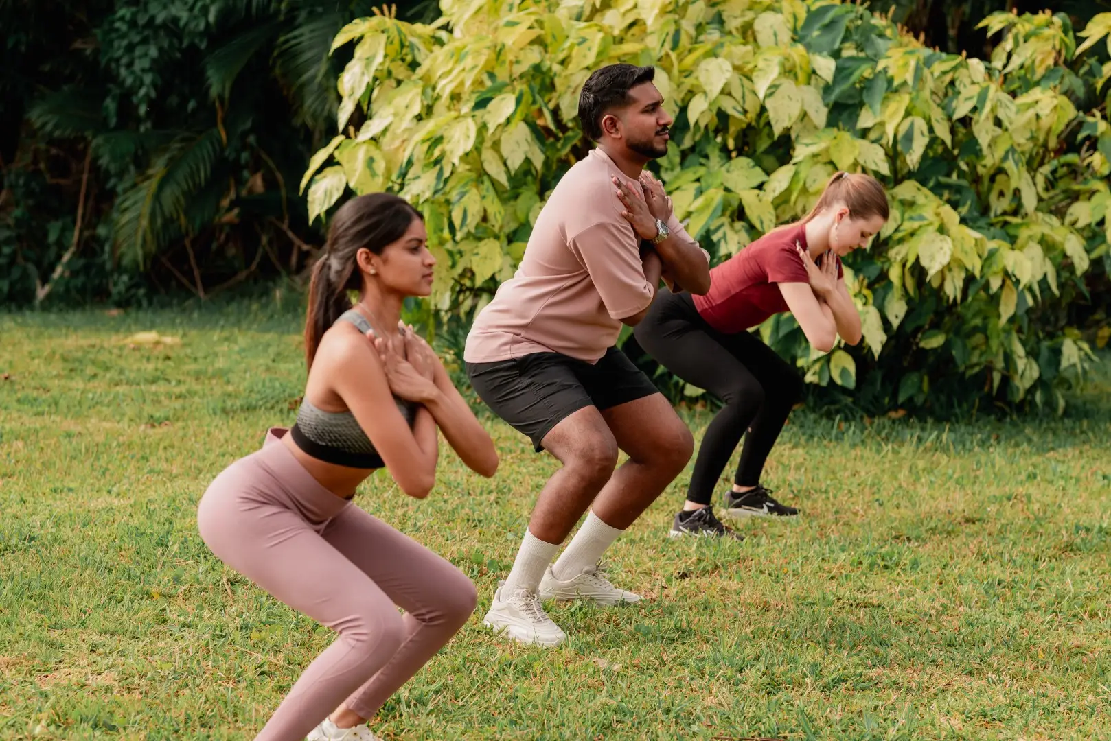 Fitness coach assisting guests with an outdoor strength exercise