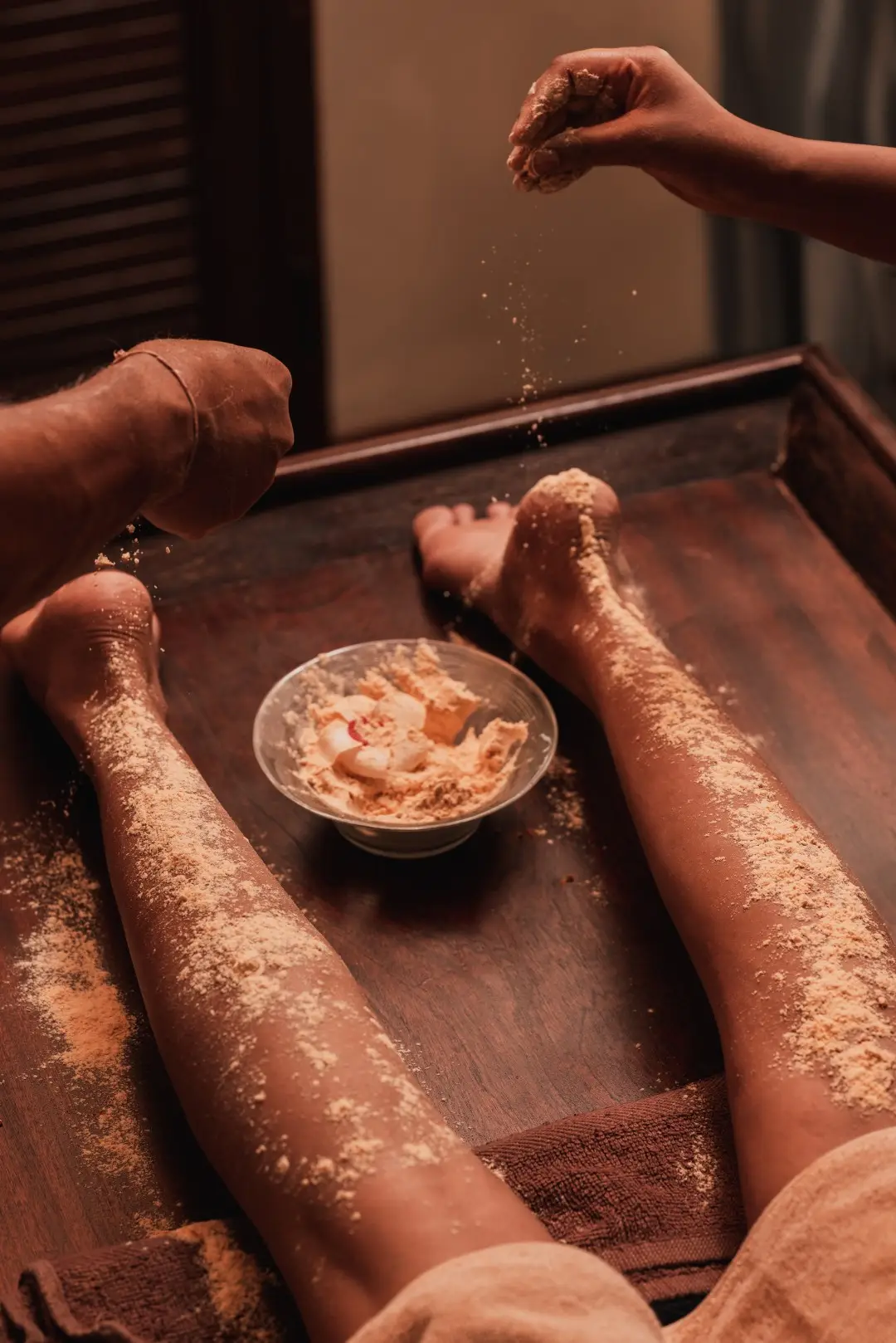 Herbal therapy bowl placed beside a guest’s feet during treatment