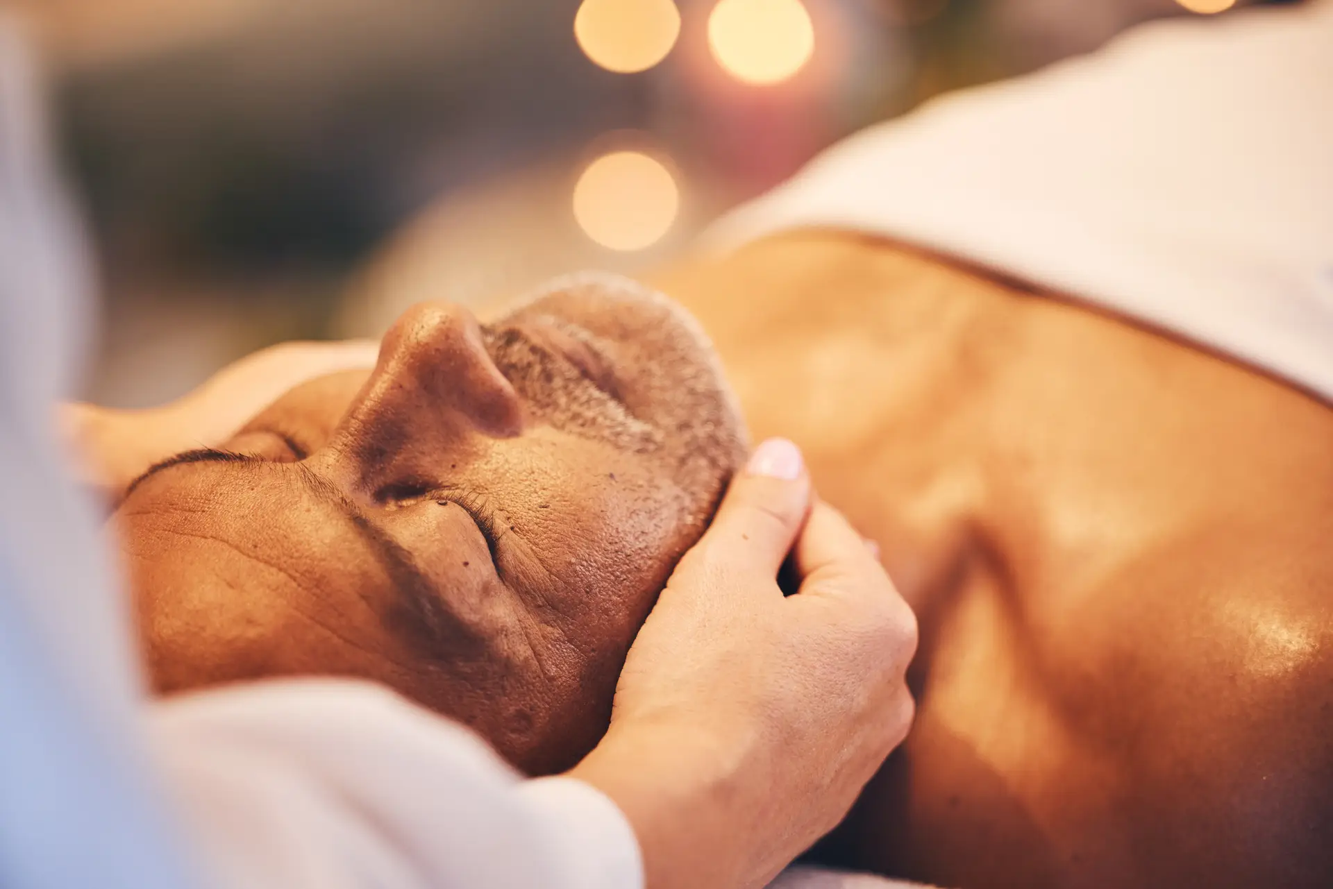 Senior man receiving a relaxing facial massage at a wellness spa