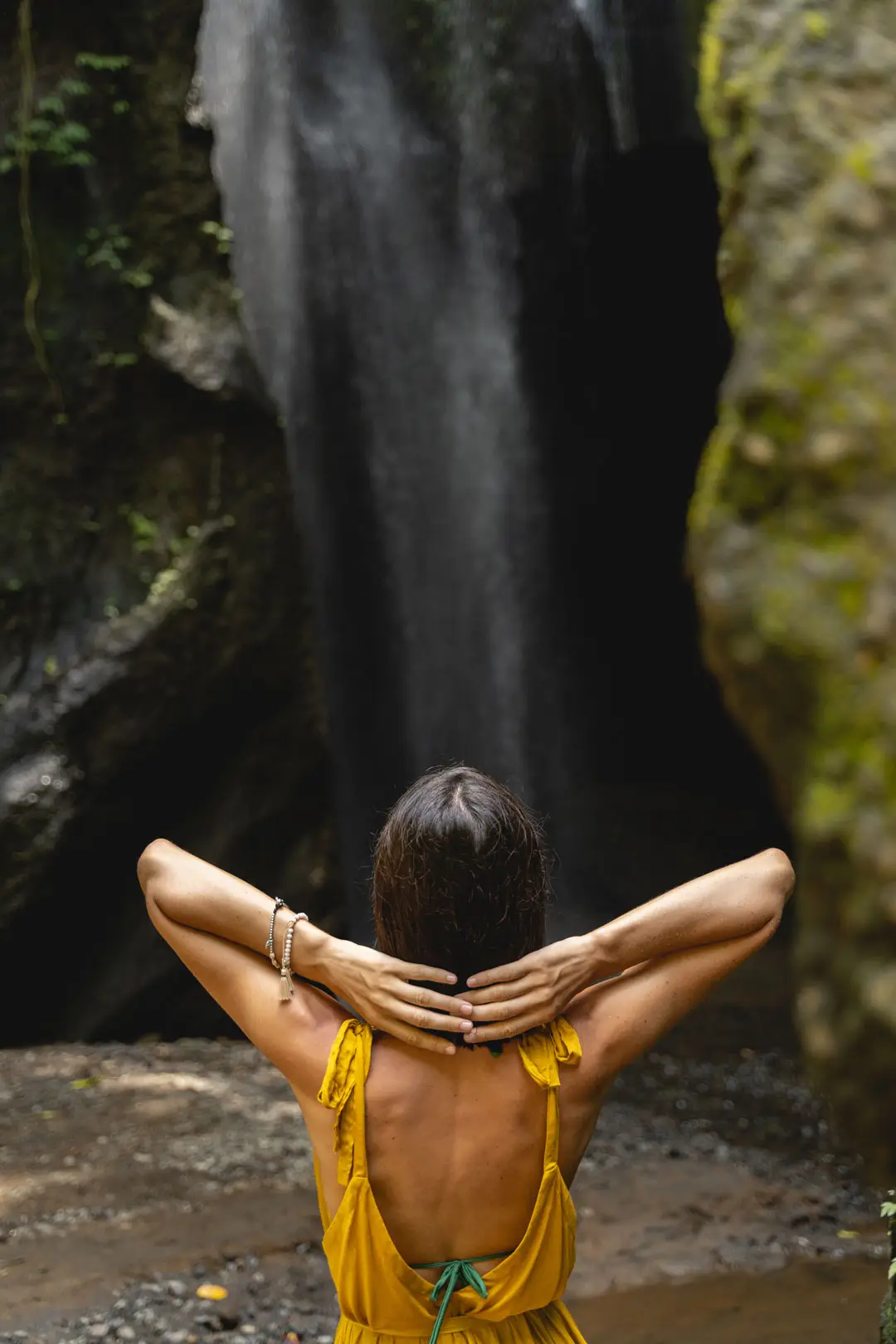 Relaxed young female person looking at waterfall